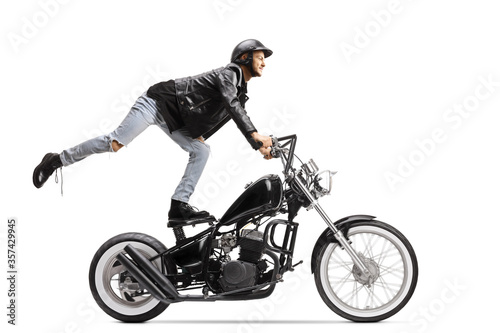 Daredevil biker standing on the seat and riding a chopper motorbike