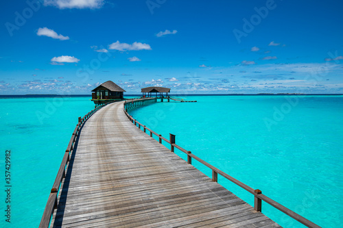 Tropical landscape of Maldives beach. Seascape panorama, luxury water villa resort with wooden pier or jetty. Luxury travel destination background for summer holiday and vacation concept.