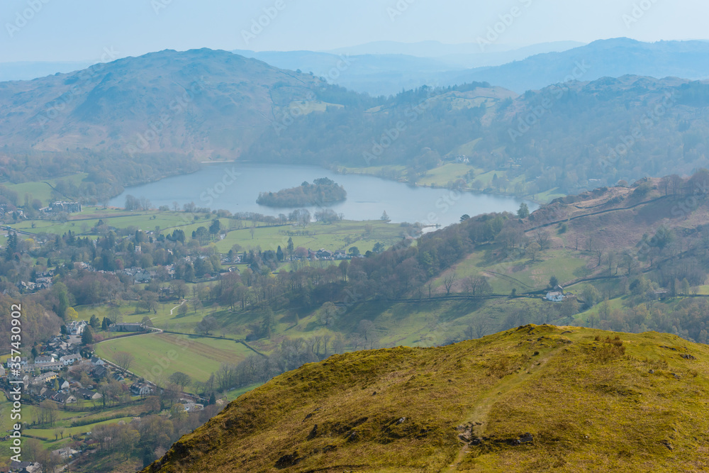 Grasmere village and lake and Loughrigg Fell in the background, seen from the summit of Helm Crag, Grasmere, Lake District National Park, Cumbria, UK.