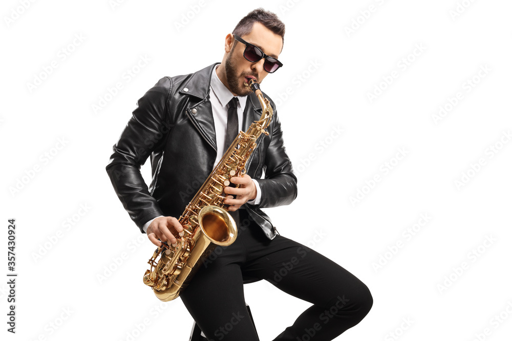 Naklejka premium Male musician in a leather jacket sitting and playing a saxophone