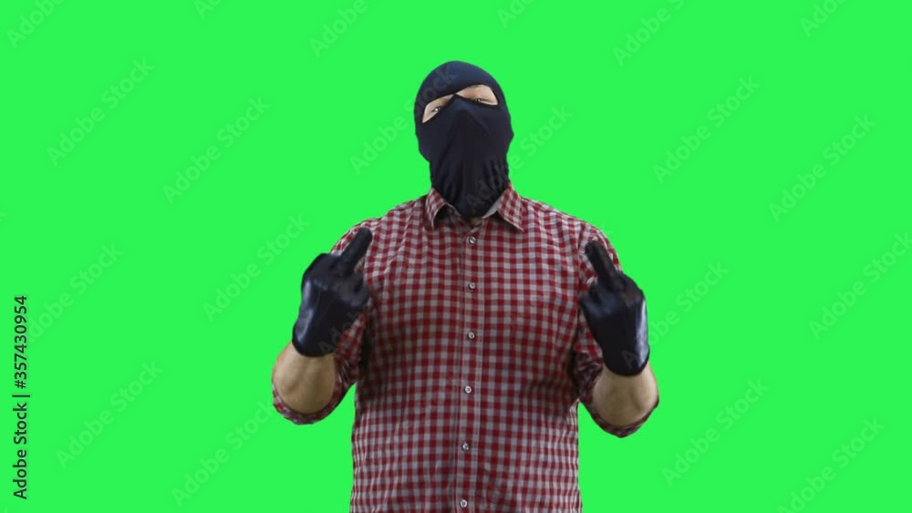 A man in a balaclava in a plaid shirt shows the middle finger with both hands.