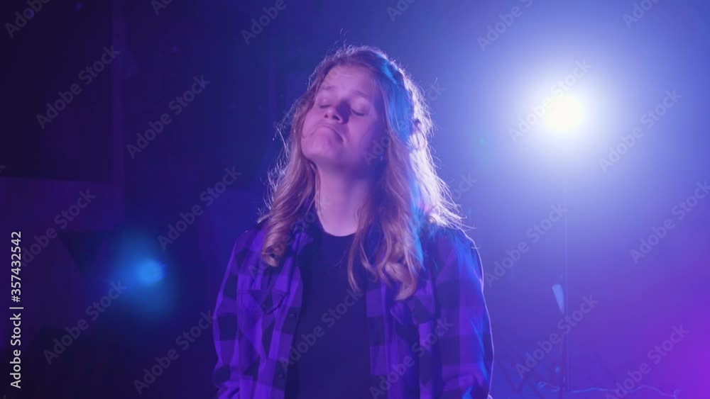 Frustrated roller skater girl in checkered shirt pout with tears in eyes in dark studio bright neon blue light. Girl on roller skates making sad grimace feeling sadness displease, frowning face Frustrated roller skater girl in checkered shirt pout with tears in eyes in dark studio bright neon blue light. Girl on roller skates making sad grimace feeling sadness displease, frowning face