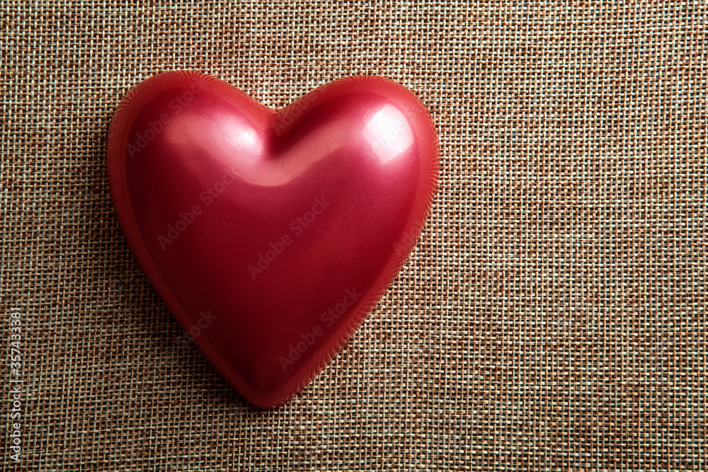 red glossy heart on linen top view red glossy heart on linen top view