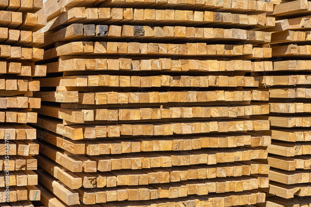 Stack of new wooden studs at the lumber yard, storage of planed wooden boards. Stack of new wooden studs at the lumber yard, storage of planed wooden boards.