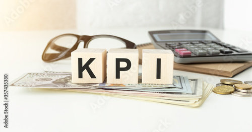 Three wooden cubes with letters KPI on white board.