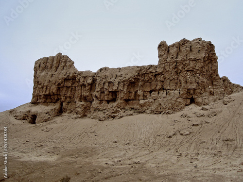 Ruins of south walls and towers of ancient Zoroastrian fortress Gyaur-Kala near medieval necropolis Mizdakhan, town Xojayli, near Nukus, Uzbekistan. Walls are about 30 feet high