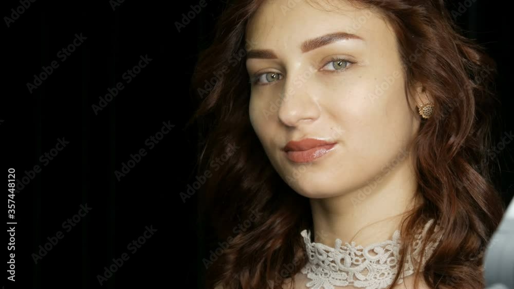 Portrait of a beautiful young woman with permanent lip makeup and microblading eyebrow tattoo posing in front of the camera in the studio. Portrait of a beautiful young woman with permanent lip makeup and microblading eyebrow tattoo posing in front of the camera in the studio.