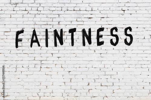 White wall with black paint inscription faintness on it