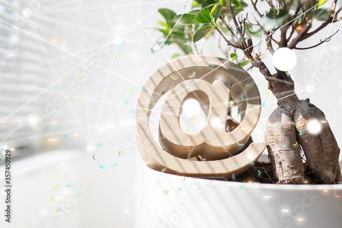фотографія Mentions icon under the plant in a white room with the illustration of a network