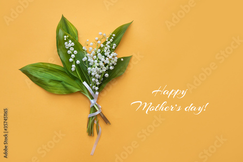 Bouquet of spring lilies of the valley on a yellow background.Bouquet of lilies of the valley for mother's day photo