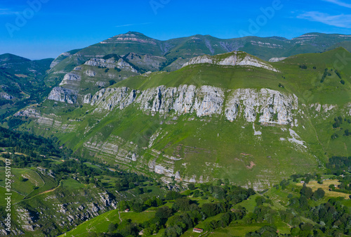 Spring landscape of mountains, meadows of mowing and cabins pasiegas in the Valle del Miera, Cantabria, Spain, Europe photo