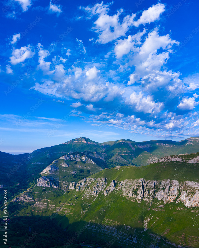 Obraz premium Spring landscape of mountains, meadows of mowing and cabins pasiegas in the Valle del Miera, Cantabria, Spain, Europe