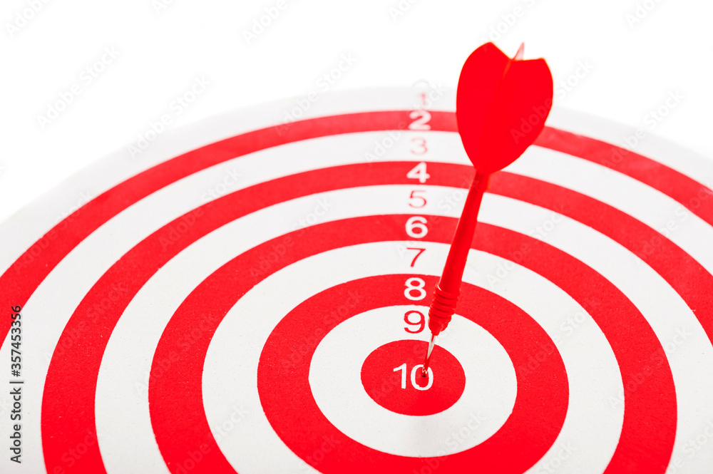 Close-Up of a Bull's Eye On a Wall with a red dart on a white background.