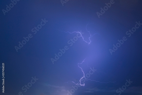 thunder storm lighting bolts in blue sky splitting and hit the sky twice