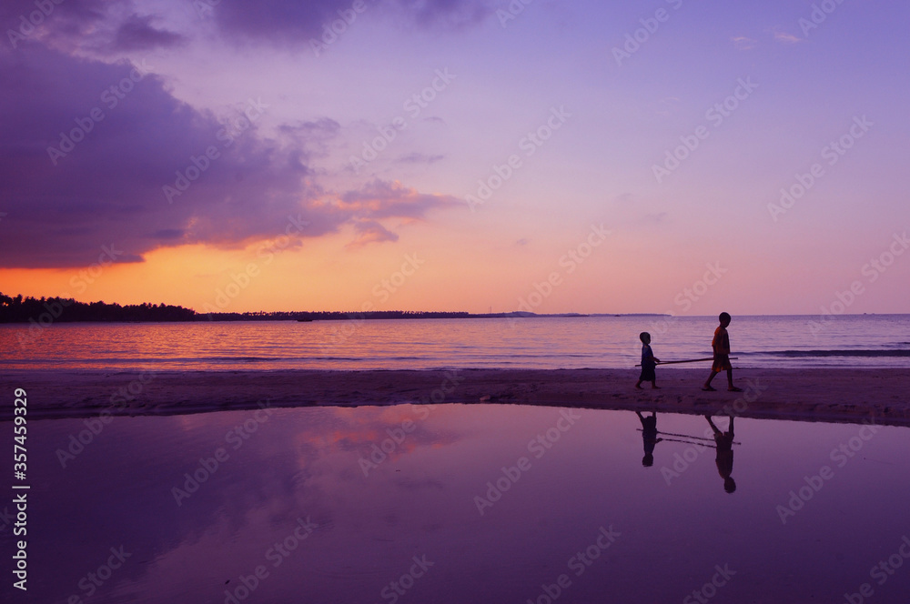 Fototapeta premium silhoutte of two local kids at Trikora Beach, Bintan, Indonesia