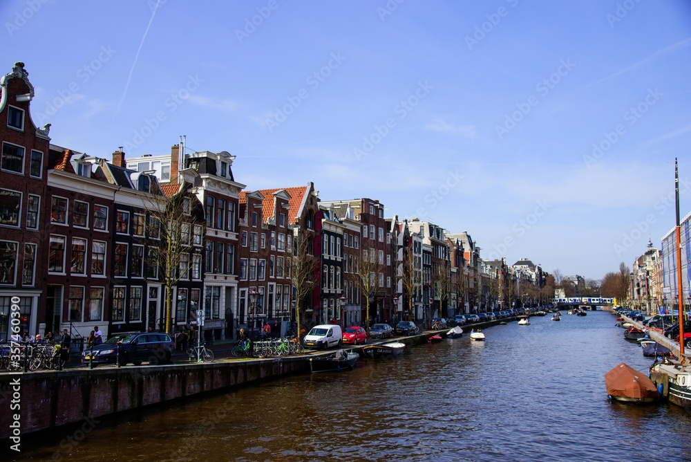 Amsterdam, Netherlands - April, 07 2018: City view of Amsterdam canals and typical houses, boats and bicycles