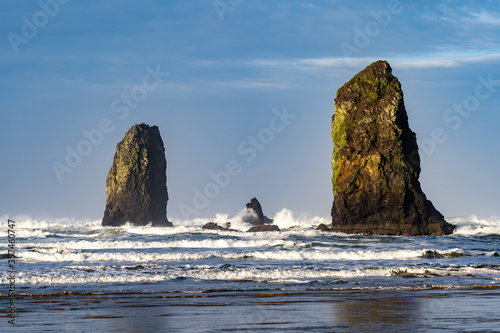 The Needles on Canon Beach in a rough sea with white capped waves and blue sky and clouds, Canon Beach, Oregon