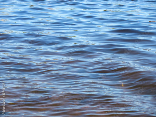 rare small waves on calm blue water. Background