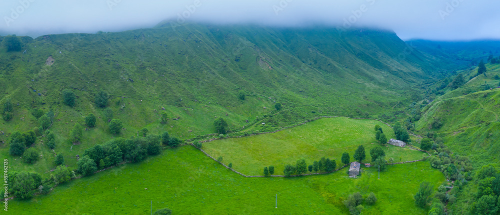 Spring landscape of mountains, meadows of mowing and cabins pasiegas near La Concha, in the Valle del Miera, Cantabria, Spain, Europe