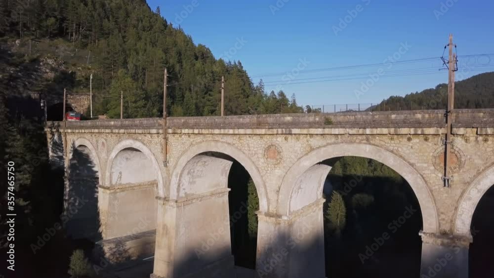 Aerial view of freight train rides on famous Kalte Rinne Viaduct on historical Semmering mountain railway (Semmeringbahn), Lower Austria. Aerial view of freight train rides on famous Kalte Rinne Viaduct on historical Semmering mountain railway (Semmeringbahn), Lower Austria.