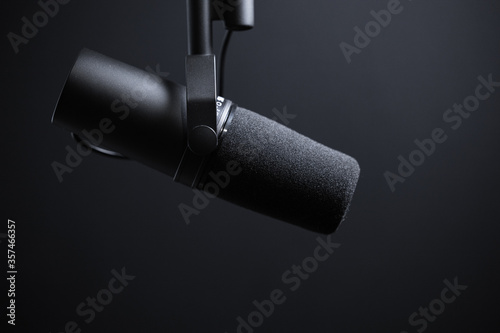 Black podcasting microphone on black background