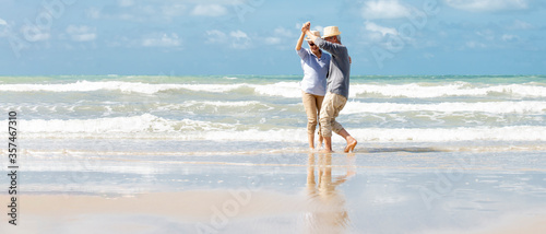 Happy  asian senior couple  dancing  on beach with blue sky background