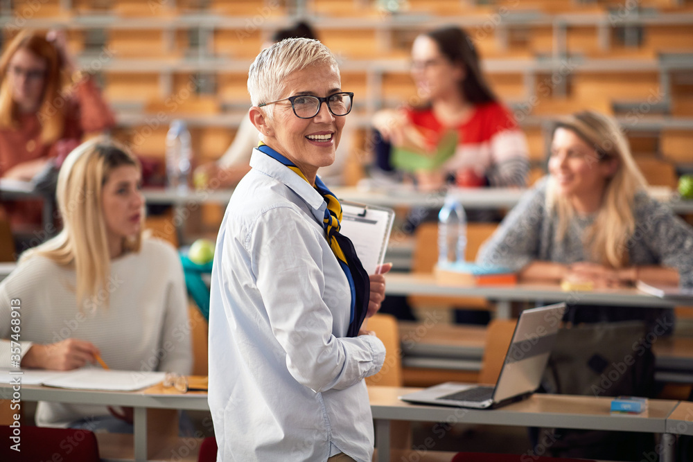 © luckybusiness - Female elderly professor giving a lecture