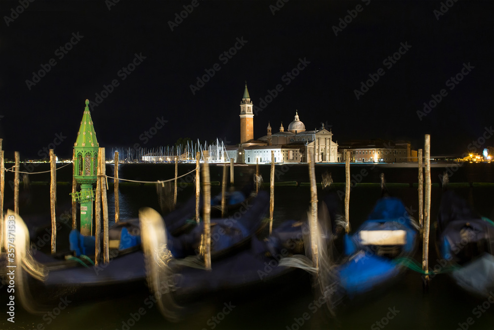 Night view of church of San Giorgio Maggiore and gondolas in blu