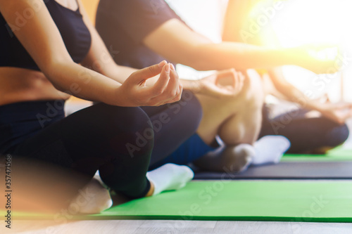Group of people doing yoga in fitness studio. Healthy lifestyle concept.