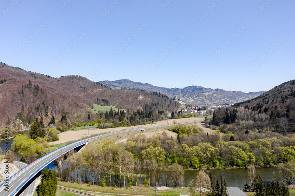 View from the top of the curved road that passes over the river, going into the distance among the mountains.