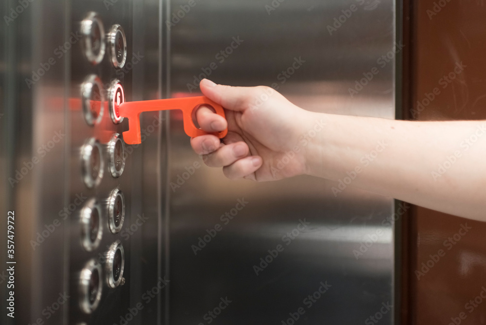 Man using a contactless tool to press a button, to avoid the Covid-19 Man using a contactless tool to press a button, to avoid the Covid-19
