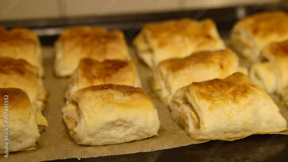 The chef sprinkles icing sugar on fresh frozen food in the kitchen. Freshly baked buns with apples in the oven. The chef sprinkles icing sugar on fresh frozen food in the kitchen. Freshly baked buns with apples in the oven.