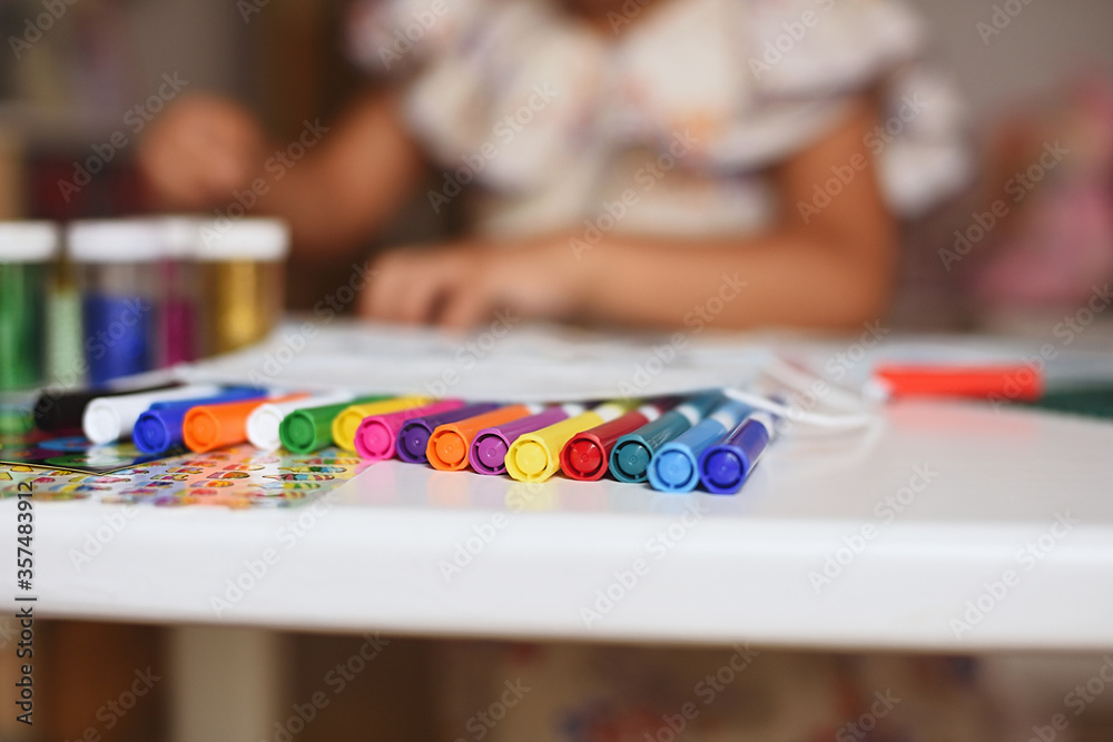 Fototapeta premium Boys' markers on a girl's bokeh table. Selective focus