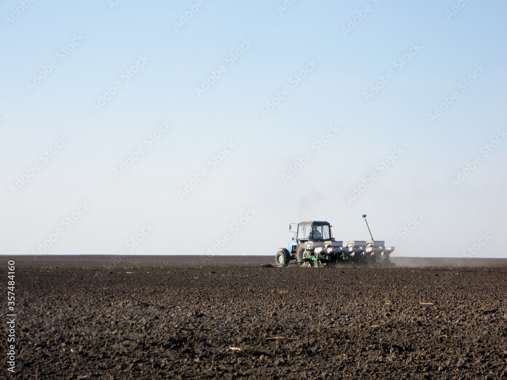 Fototapeta premium Plowed field by tractor in brown soil on open countryside nature