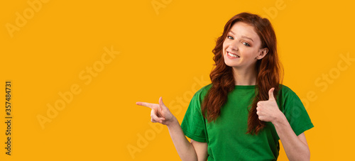 Millennial Girl Pointing Finger Aside Gesturing Thumbs Up, Yellow Background