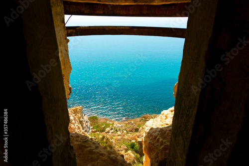 An ancient exit from the defensive structure to the rocks at the sea shore. View of the turquoise sea. Cape Fiolent