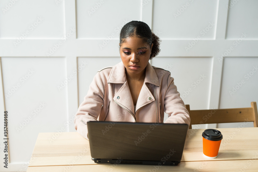 beautiful young african woman at the table with laptop beautiful young african woman at the table with laptop