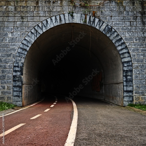 camino de viandantes y bicletas introduciendose en la oscuridad de un tunel