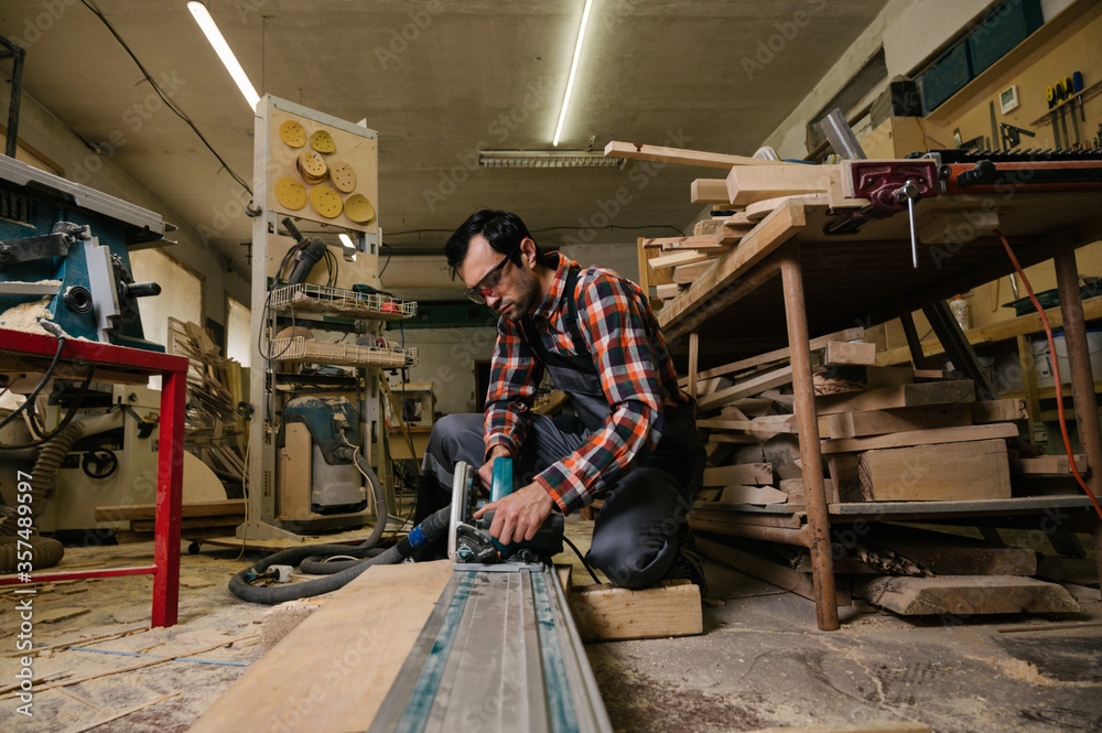 A man works on a circular saw A man works on a circular saw