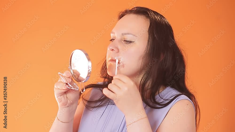 Young brunette woman smears a real burn on her face with a cotton swab cream Young brunette woman smears a real burn on her face with a cotton swab cream