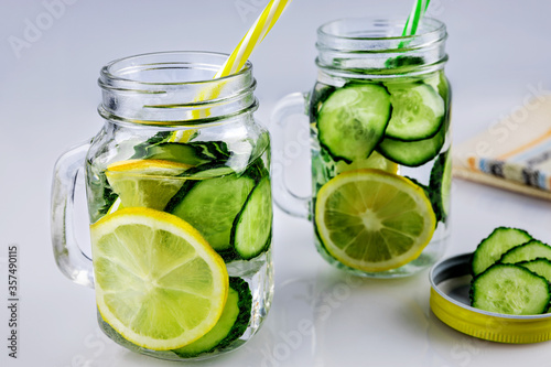 Cold drink, two retro glass cup of lemonade with cucumber and lemon on a white background, shallow depth of field, selective focus. Health drink concept.