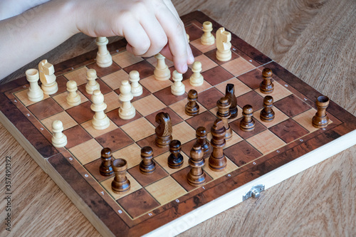 Obraz na płótnie A child's hand moves a chess piece. Educational Intelligent Games w salonie