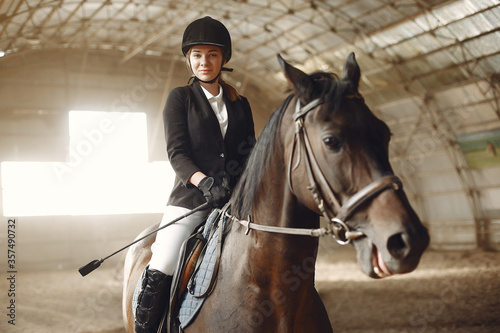 Woman on a horseback. Rider in a black uniform © prostooleh