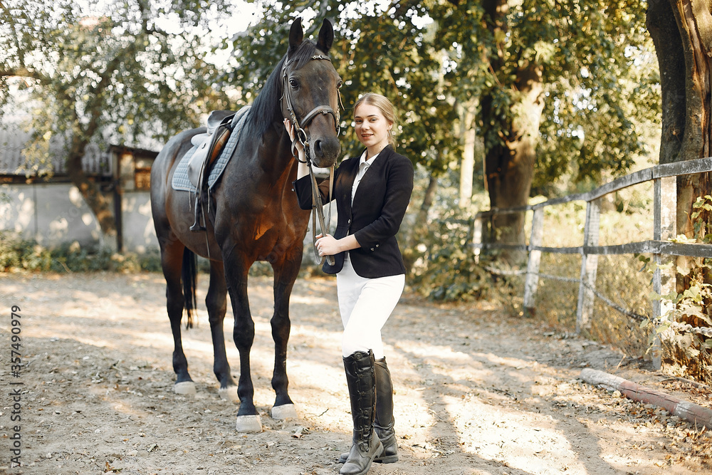 Woman near horse. Rider in a black uniform Woman near horse. Rider in a black uniform