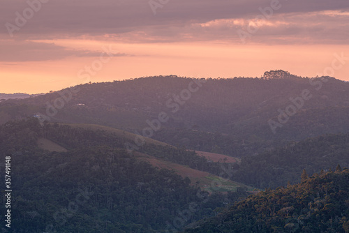 P  r-do-sol na regi  o serrana do Estado do Esp  rito Santo  Brasil  mostrando vales e morros cobertos de mata.