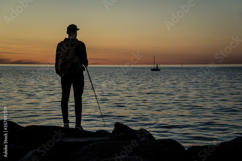 silhouette of a man on the beach fishing