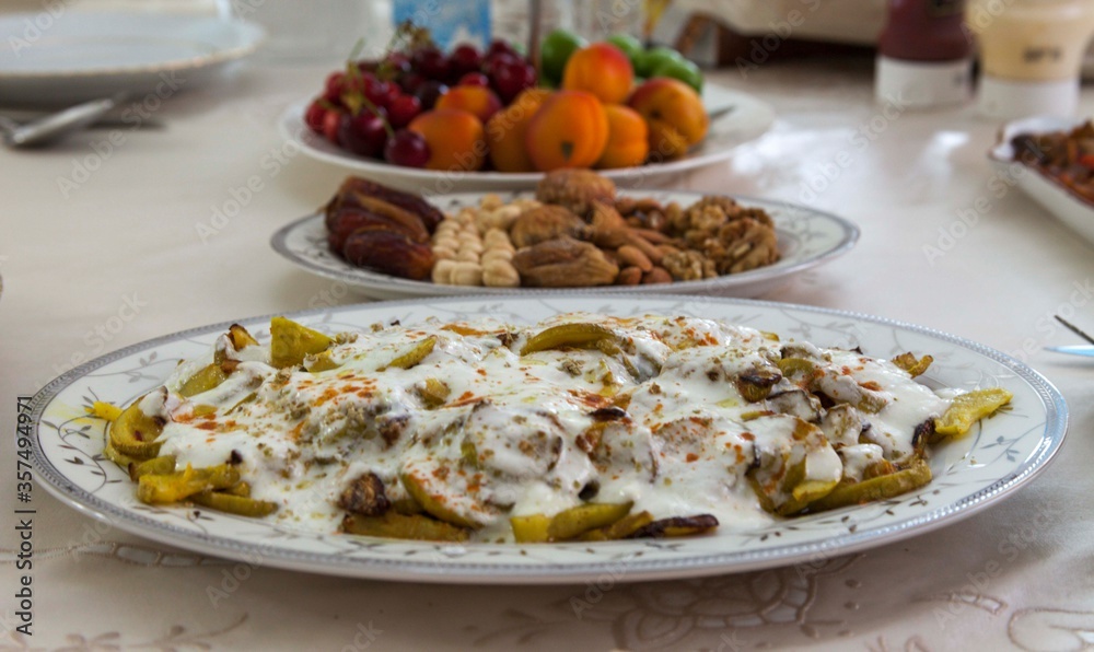 zucchini with yogurt is in focus and the rest of the plates are out of focus. Appetizers and fruits on the table. Ramadan Kareem. Ramadan Iftar table with variety of foods.