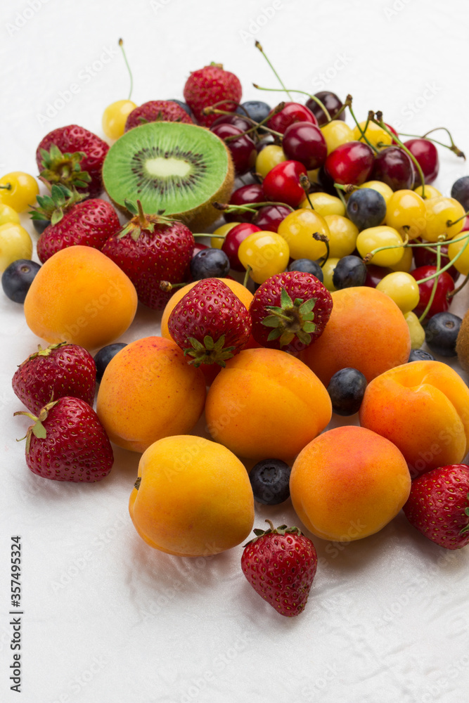 Assorted fresh berries and fruits. Apricots Kiwi Strawberry Cherry Blueberry on white Assorted fresh berries and fruits. Apricots Kiwi Strawberry Cherry Blueberry on white