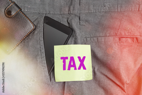 Word writing text Tax. Business photo showcasing compulsory financial charge imposed upon taxpayer by government Smartphone device inside trousers front pocket with wallet and note paper photo