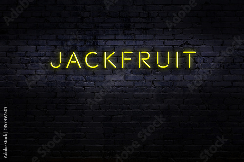 Night view of neon sign on brick wall with inscription jackfruit